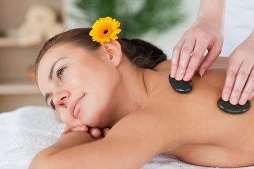 Obraz na płótnie Canvas Close up of a cute woman enjoying a hot stone massage