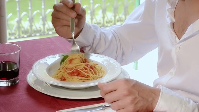 un uomo mangia un piatto di spaghetti