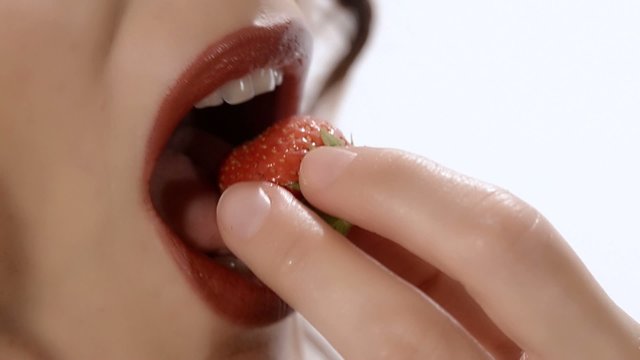una donna gusta una fragola