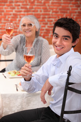 Young man having dinner with his grandmother