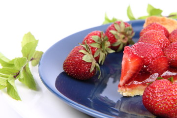 Piece of Strawberry Tart decorated with strawberries and mint