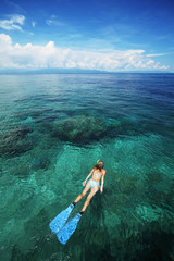 Young woman snorkeling in a coral reef in the tropical sea. Bunaken island. Indonesia