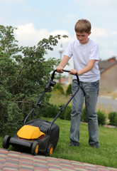 Teen boy  mows the lawn mower electric - 33484710