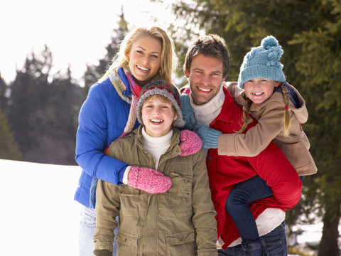 Young Family  In Alpine Snow Scene