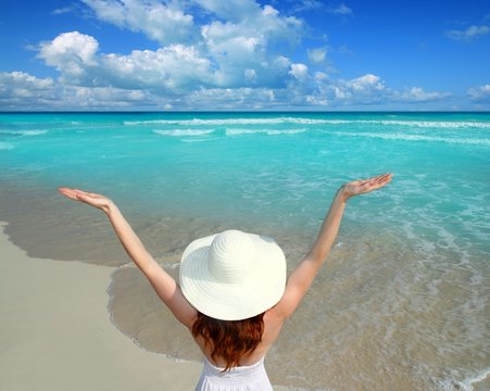 Caribbean beach woman rear view hat open arms