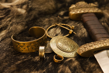 Still life with scandinavian jewels and sword on a fur - obrazy, fototapety, plakaty
