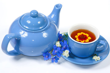 The blue kettle and cup of tea with nice flowers