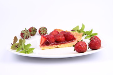 Piece of Strawberry Tart decorated with strawberries and mint