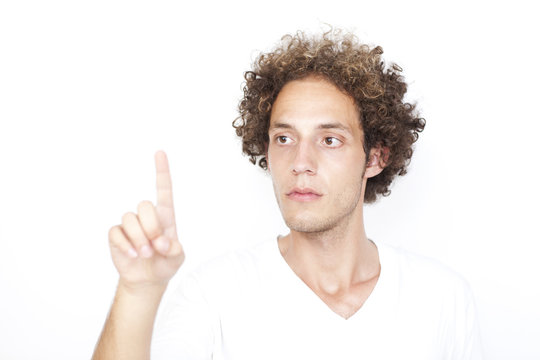 Junger Mann mit Locken dr&uuml;ckt auf virtuellen Schirm