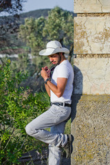 Ragazzo appoggiato al muro mentre fuma un sigaro