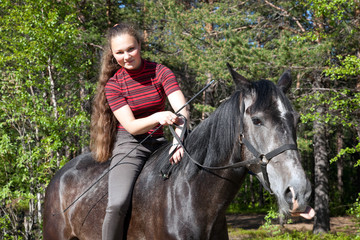 Fototapeta premium Beautiful girl on black horse