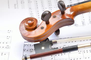 Naklejka premium Violin scroll with bow and music