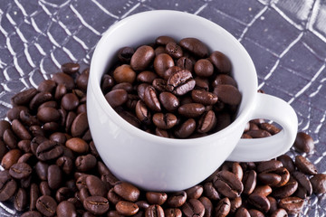 Chicchi di caffè in tazzina bianca