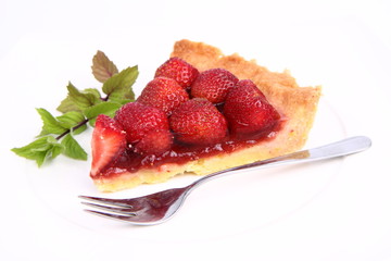 Piece of Strawberry Tart on white plate with mint twig