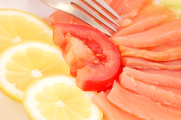 Fresh salmon steak with lemon slice and tomato