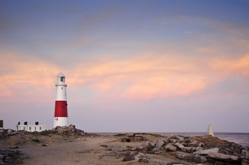 Fototapeta na wymiar Victorian lighthouse on promontory of rocky cliffs during stunni