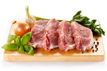 Raw pork on cutting board and vegetables
