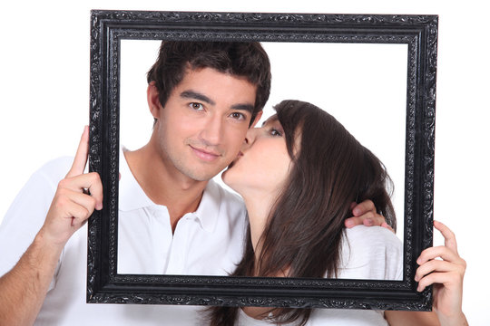 Young couple kissing in a frame