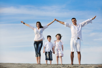 family on beach showing home sign