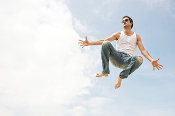 Obraz premium Man jumping against blue sky