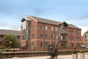 Office Block by a canal under a blue sky with antique crane