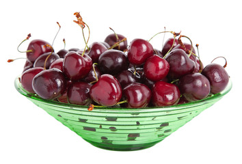 ripe cherries in a green bowl over white background.