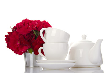 Fototapeta na wymiar White crockery for tea and a bouquet of roses