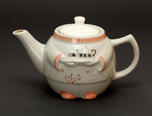 Чайник заварочный на тёмном фоне.