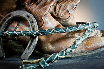 Cowboy  boots,horseshoe and whip on wood
