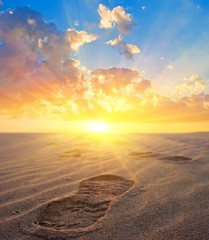 man footprint on a sand at the sunset