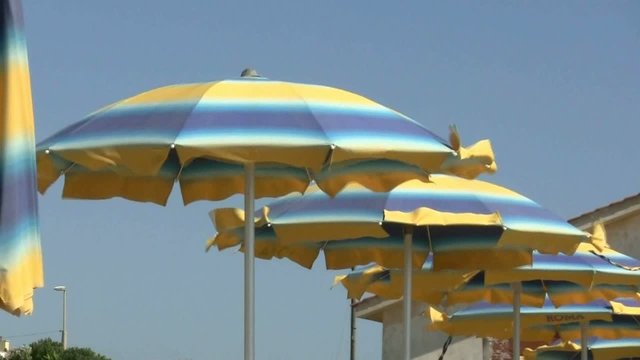 Ombrelloni sulla spiaggia smossi dal vento