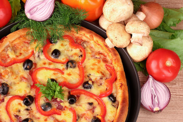 tasty pizza with olives and vegetables on a wooden background