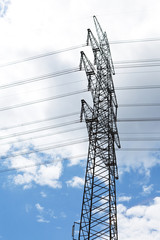 electrical tower with powerlines over a cloudy sky
