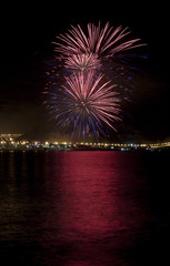 Fuegos artificiales con reflejo en el agua