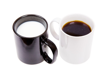Black cup with milk and a white cup with black coffee.