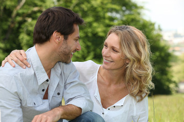 Relaxed loving couple sitting in the park
