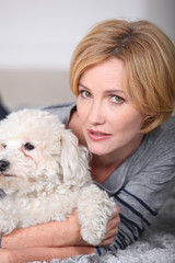 Woman hugging her little white dog