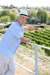Man on holiday pointing at vineyard