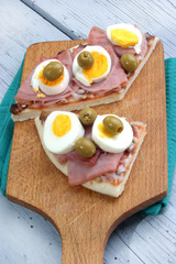 Pizza mit gekochtem Schinken, Ei und Oliven