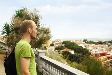 Fototapeta na wymiar young man on hill looking at European city