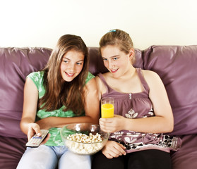 Obraz na płótnie Canvas Two female friends watching televison