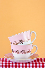 Two retro style teacups on gingham cloth