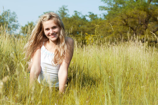 Beautiful young woman in a green field