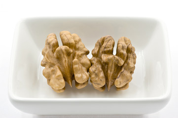 Два ядра грецкого ореха в блюдце