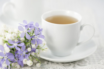 Obraz na płótnie Canvas Filiżanka herbaty i kwiatów