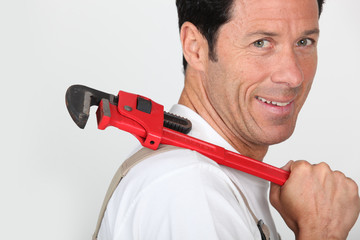 Plumber holding wrench over shoulder