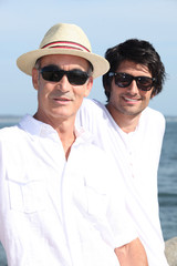 Father and son sat by waterfront