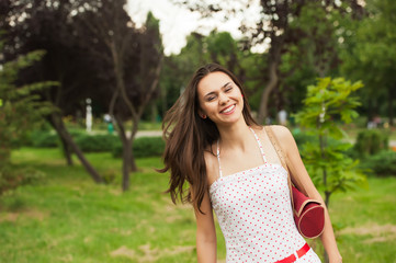 Fototapeta premium portrait of a beautiful young girl in a park on a background
