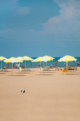 Sandy beach with parasols by the sea