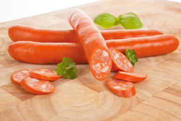 Sausages on wooden cutting board.
